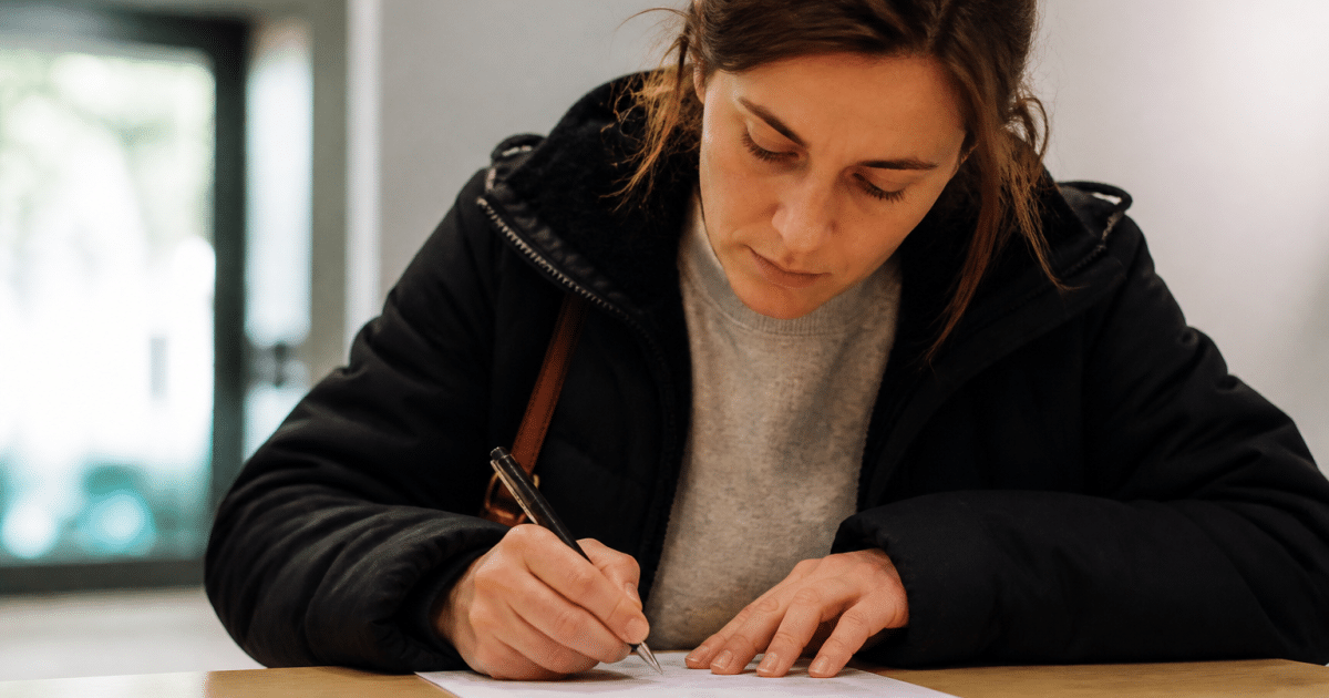 Personne remplissant formulaire administratif blanc sur bureau