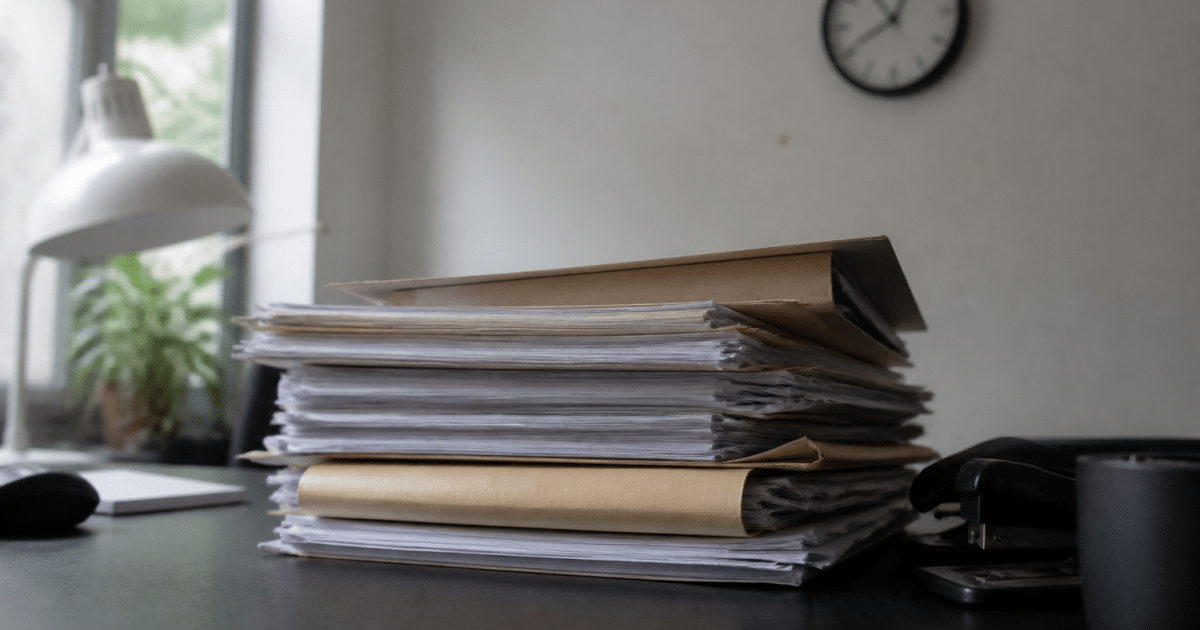 Dossier papier empile sur bureau avec horloge murale