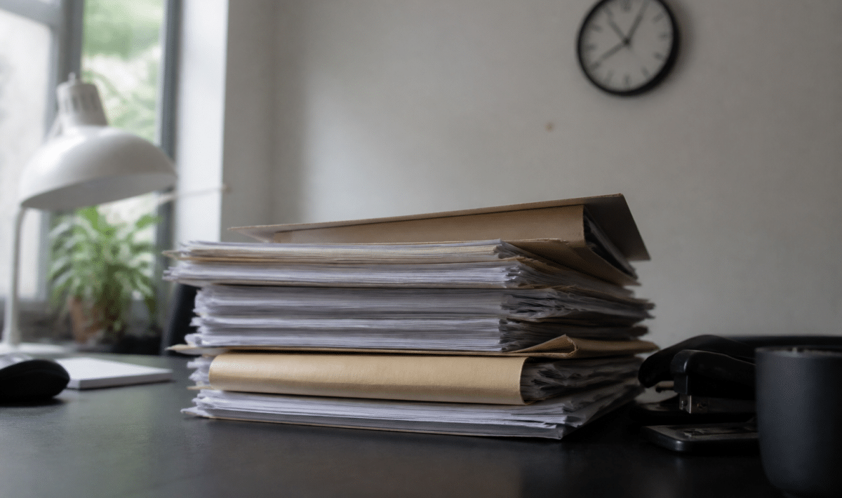 Dossier papier empile sur bureau avec horloge murale