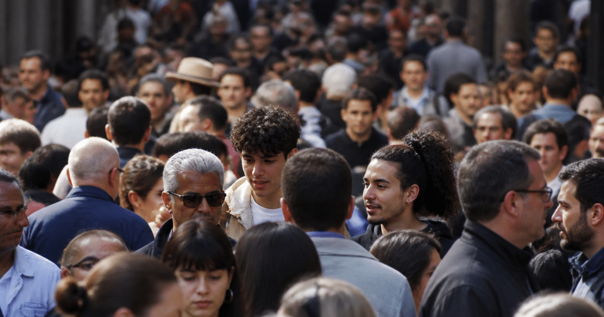Foule dense de personnes debout serrées ensemble dans rue urbaine