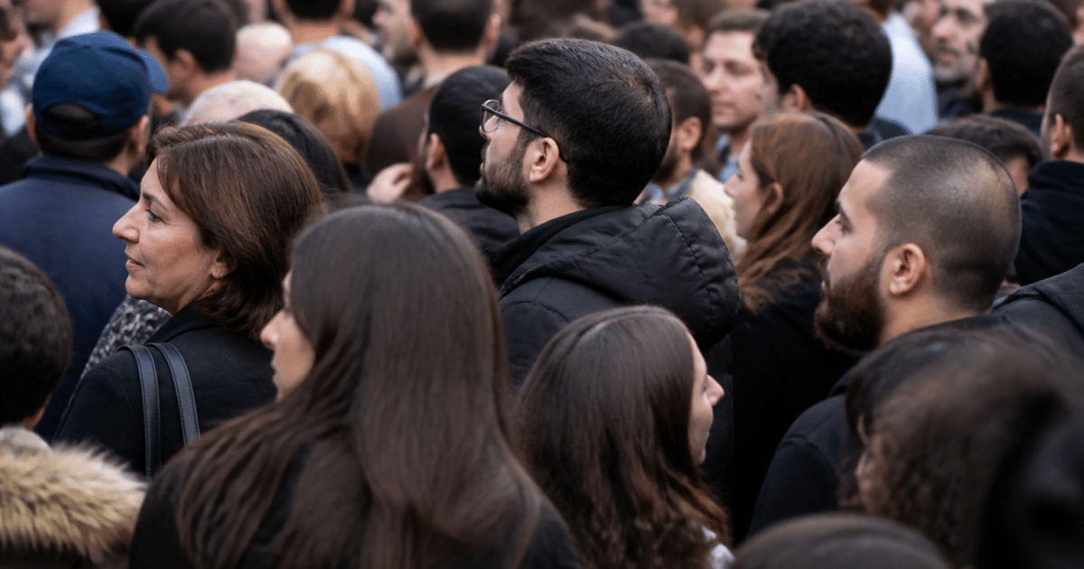 Foule de personnes debout serrees dans rue urbaine