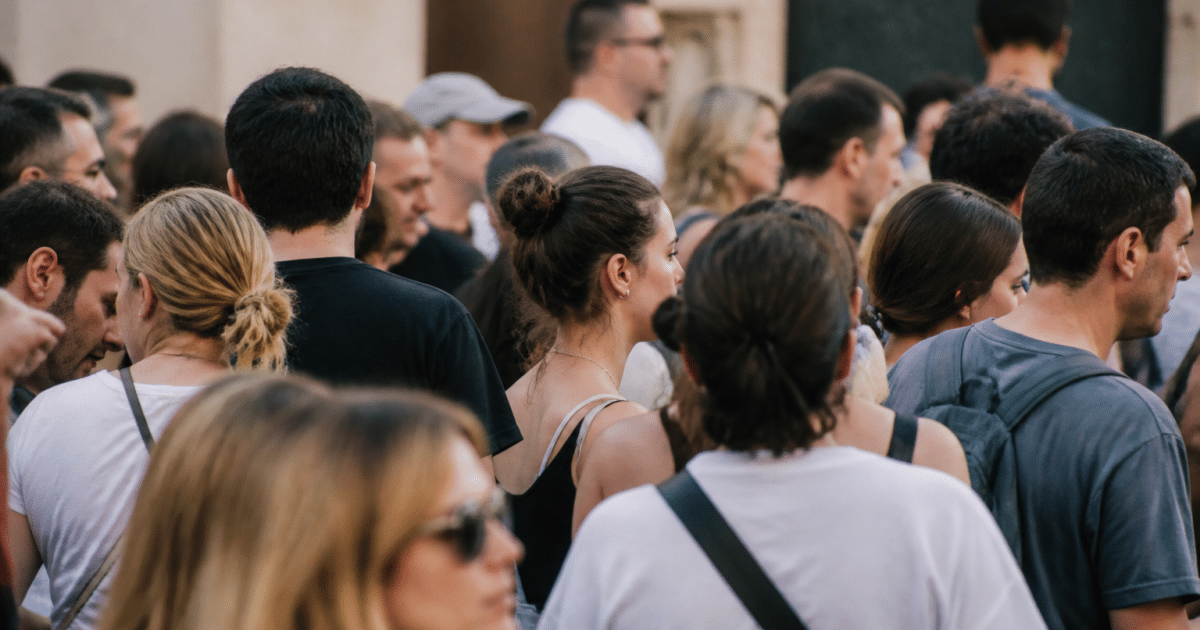 Foule dense de personnes debout dans rue urbaine lyonnaise