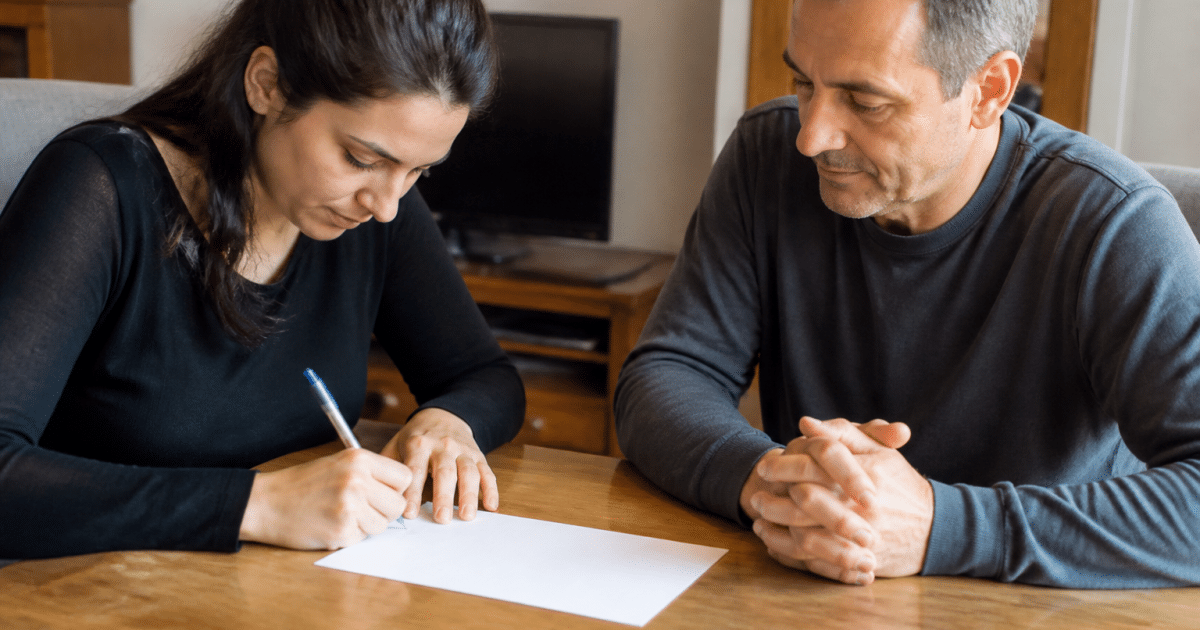 Deux personnes signent document pret argent face a face