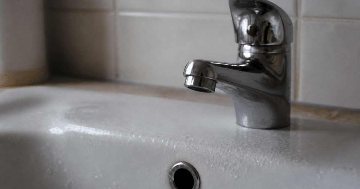 Robinet ferme avec gouttes d'eau immobile sur evier blanc