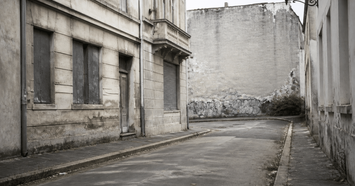 Rue urbaine déserte avec immeubles dégradés et graffitis visibles